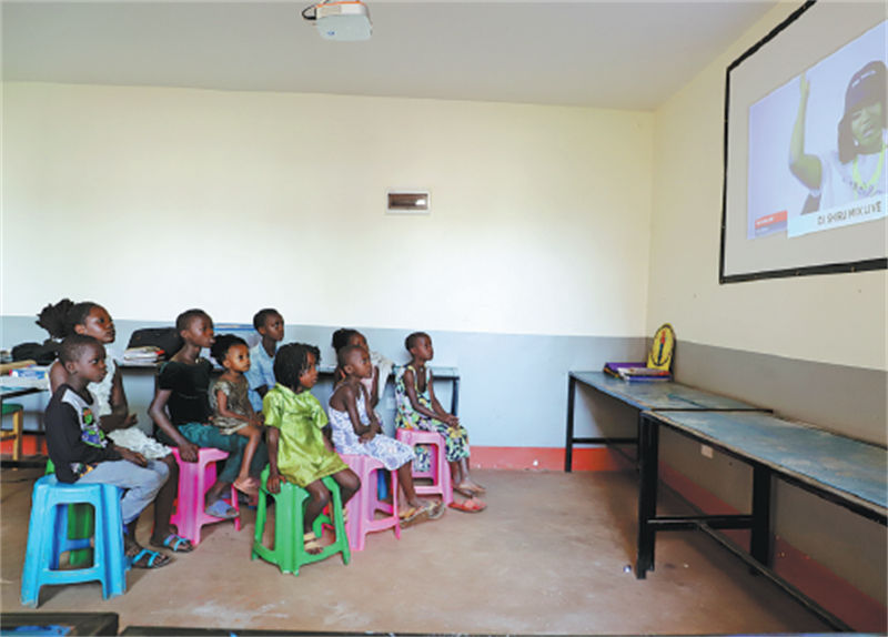 Watoto wakitazama televisheni kwa kupitia projekta Tarehe 10, Septemba, 2021 katika Shule ya Kijiji cha Bwerenga, Wilaya ya Wakiso, katikati ya Uganda. Kutokana na msaada wa China, wanaweza kuunganishwa na Dunia kwa kupitia satelaiti ya kidijitali. Zhang Jiaping/Tovuti ya Shirika la Habari la China, Xinhua