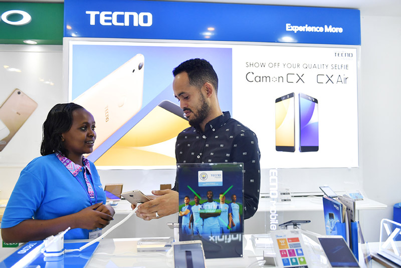 Muuzaji akimuonesha mteja simu mahiri ya Tecno kutoka Kampuni ya China ya Transsion Holdings mjini Nairobi, Kenya. (Picha/Xinhua)