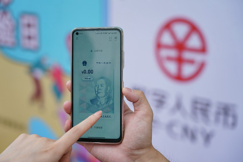 Mfanyakazi wa Benki ya Mawasiliano akionesha jinsi ya kutumia mikopo ya mtandaoni ya e-CNY kwenye Bustani ya Huanlegu hapa Beijing, Mji Mkuu wa China. (Xinhua/Chen Zhonghao)