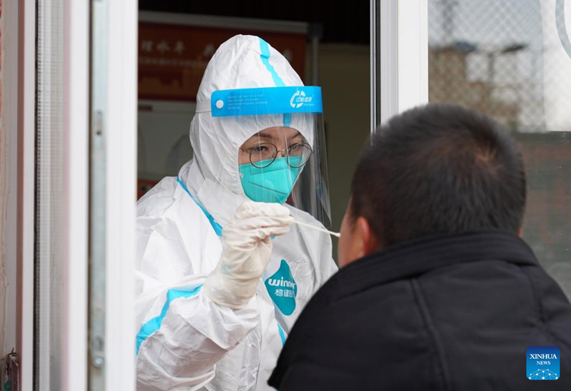 Mhudumu wa afya akichukua sampuli ya mkazi kwenye kituo cha kupima virusi vya korona  kwenye Eneo la Magharibi la  Beijing, mji mkuu wa China, Januari 26, 2022. (Xinhua/Ren Chao)
