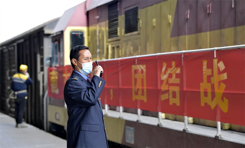 Mfanyakazi kwa pamoja na mwenzake akiratibu kuwezesha kuondoka kwa treni ya mizigo katika kituo cha mizigo huko Lhasa, Mkoa wa Tibeti nchini China, Aprili 10, 2022. (Xinhua/Zhang Rufeng)