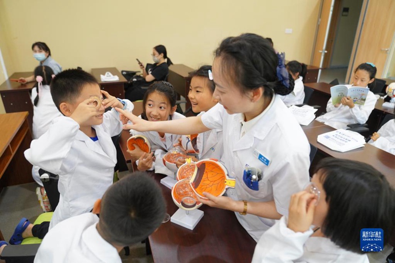 Tarehe 5, Juni, daktari wa macho akiwaelezea watoto ujuzi kuhusu mundo wa mboni za macho katika hospitali ya macho ya eneo la Beibei la Mji wa Chongqing. (Picha/Xinhua)
