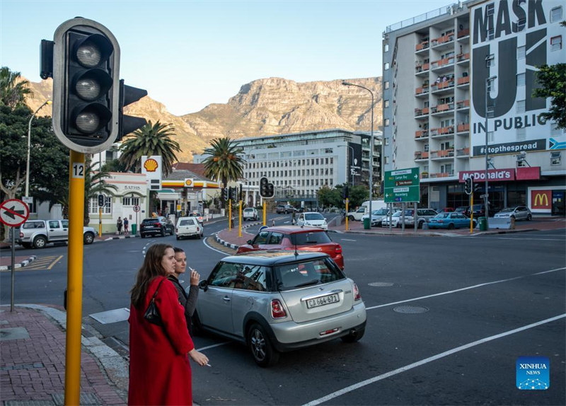 Watu wakisubiri kuvuka barabara wakati wa kukatwa kwa umeme huko Cape Town, Afrika Kusini, Juni 28, 2022. Shirika la Umeme la Afrika Kusini, Eskom Jumanne wiki hii limetangaza kwamba lilibadilisha kiwango cha uzalishaji umeme kutoka Hatua ya 4 ya sasa hadi hatua kali zaidi ya 6 katika baadhi ya vipindi siku za Jumanne na Jumatano, ikitoa sababu ya mgomo wa wafanyakazi unaohusiana na madai ya mishahara ambao umesababisha kutatiza mitambo ya shirika hilo. (Xinhua/Lyu Tianran)