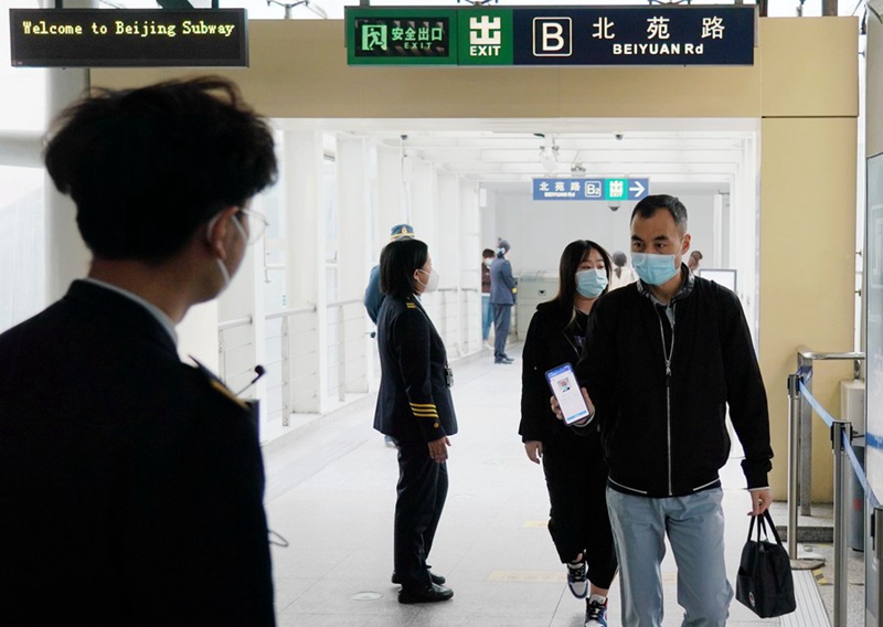 Msafiri akionesha alama yake ya afya kabla ya kuingia kituo cha sabwe cha Beijing, Mei 17, 2022. (Picha/Xinhua)