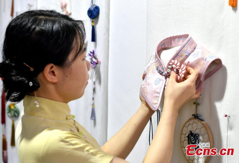 Msichana anayejikita katika kufuma vifungo vya nguo vya jadi vya China