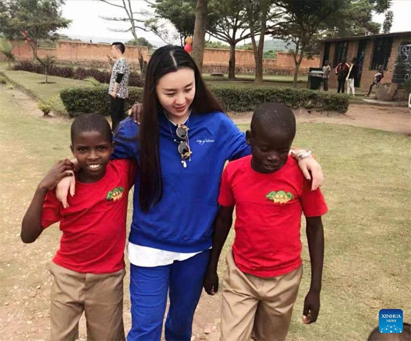 Picha kutoka maktaba iliyopigwa Tarehe 20 Desemba 2018 ikimwonyesha mwanamke mfanyabiashara kutoka China Yang Jing akitembea na wanafunzi wawili katika kituo cha watoto yatima huko Kigali, Rwanda. Yang Jing, mmiliki wa Hoteli ya Dmall huko Kigali, Mji Mkuu wa Rwanda, anasema tangu alipoanza kufanya shughuli zake, amesaidia mamia ya watoto nchini China na kote barani Afrika akilenga watu binafsi na makundi. (Xinhua)