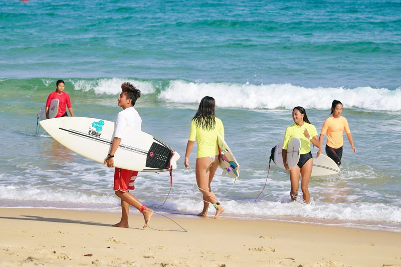 Watu wateleza kwenye mawimbi na kufurahia mandhari nzuri ya Wanning, Hainan