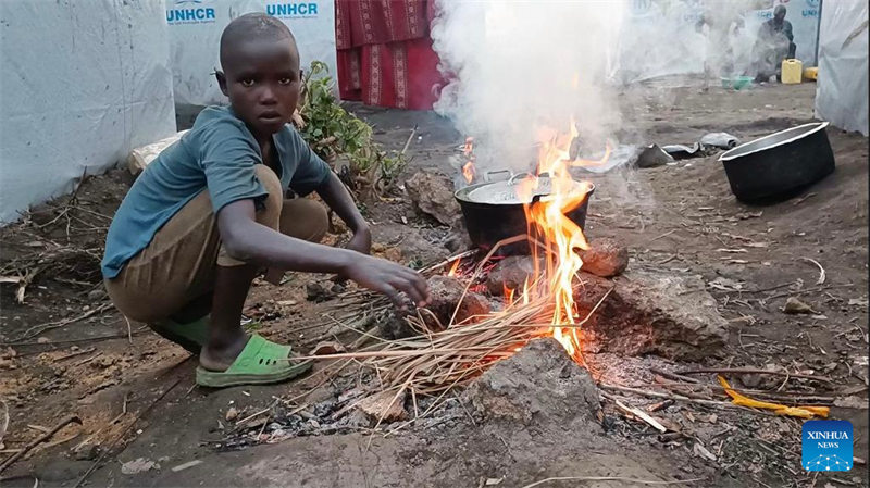 Picha iliyopigwa Septemba 18, 2022 ikionyesha mtoto aliyekimbia makazi yake anapika kwenye jiko la muda katika makazi ya muda huko Rumangabo, Jimbo la Kivu Kaskazini, Jamhuri ya Kidemokrasia ya Congo (DRC). (Xinhua/Alain Uaykani)