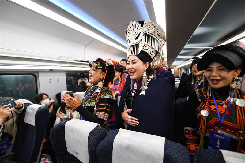 Watu wa kabila la Wayi wakiimba kwa furaha kwenye treni ya Fuxing yenye nambari C57 inayoendeshwa kwenye Reli mpya ya mwendokasi ya Chengdu-Kunming, Kusini Magharibi mwa China, Desemba 26, 2022.(Xinhua/Wang Xi)