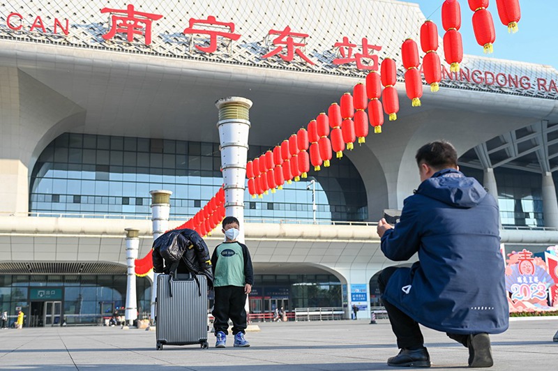 Baba huyu akimpigia mtoto wake picha mbele ya Kituo cha treni cha Mashariki cha Nanning, Mkoa wa Guangxi wa China, katika siku ya kwanza ya pilikapilika za usafiri wa mwaka mpya wa jadi wa China Tarehe 7, Januari, 2023. (Picha na Yan Lizheng/People’s Daily Online)
