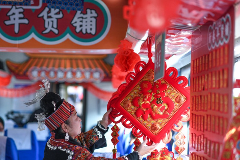Abiria akichagua mapambo ya Mwaka Mpya wa Jadi wa China kwenye treni namba 5640 katika Mkoa wa Guizhou, Kusini Magharibi mwa China, Januari 10, 2023. (Xinhua/Yang Wenbin)