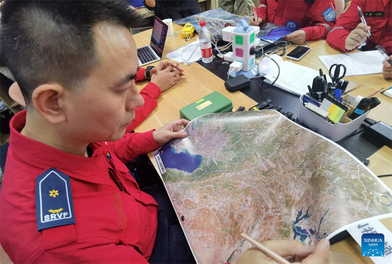 Mwokoaji wa Shirikisho la Waokoaji wa Kujitolea la Shenzhen, China akitazama ramani ya eneo lililokumbwa na janga kabla ya kuondoka Shenzhen, Mkoa wa Guangdong, Kusini mwa China, Februari 8, 2023. Kikosi cha kutangulia chenye watu 6 waliobeba vifaa vya kutambua na vya kusaidia kikosi cha Shirikisho la Waokoaji wa kujitolea la Shenzhen kimeelekea Uturuki kupitia Hong Kong siku ya Jumatano kushiriki katika juhudi za utoaji misaada kwa waathirika wa tetemeko la ardhi huko. (Xinhua/Mao Siqian)