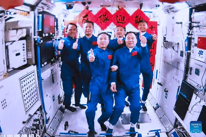 Picha hii kutoka kwenye skrini iliyopigwa katika Kituo cha Udhibiti wa Safari ya Anga ya Juu cha Beijing Mei 30, 2023 ikionyesha wanaanga wa China wa Chombo cha Shenzhou-15 na wale wa Chombo cha Shenzhou-16 wakipiga picha ya kundi ndani ya moduli kuu ya Tianhe ya kituo cha anga ya juu cha China. (Xinhua/Li Jie)
