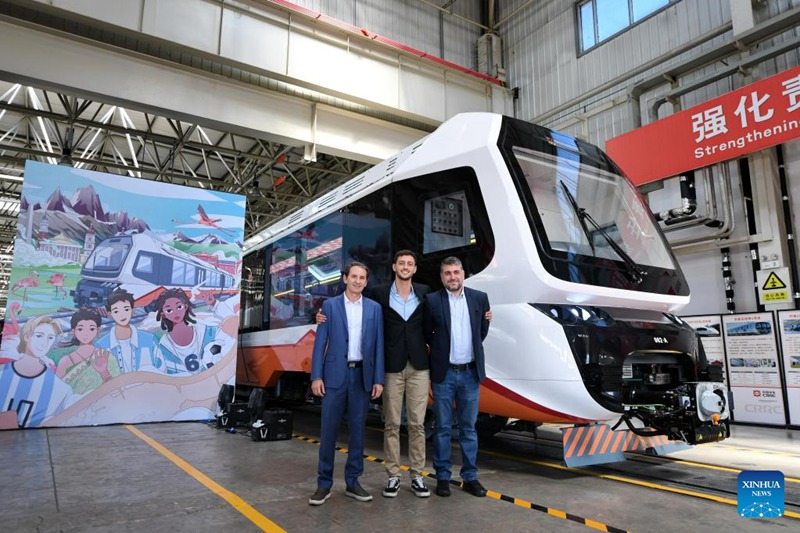 Wageni kutoka Argentina wakipiga picha mbele ya treni ya kwanza inayotumia nishati mpya ya kuendeshwa kwenye reli nyepesi iliyoundwa na Kampuni ya CRRC Tangshan kwa ajili ya Argentina huko Tangshan, Mkoa wa Hebei, Kaskazini mwa China, Juni 6, 2023. (Xinhua/Gao Bo)