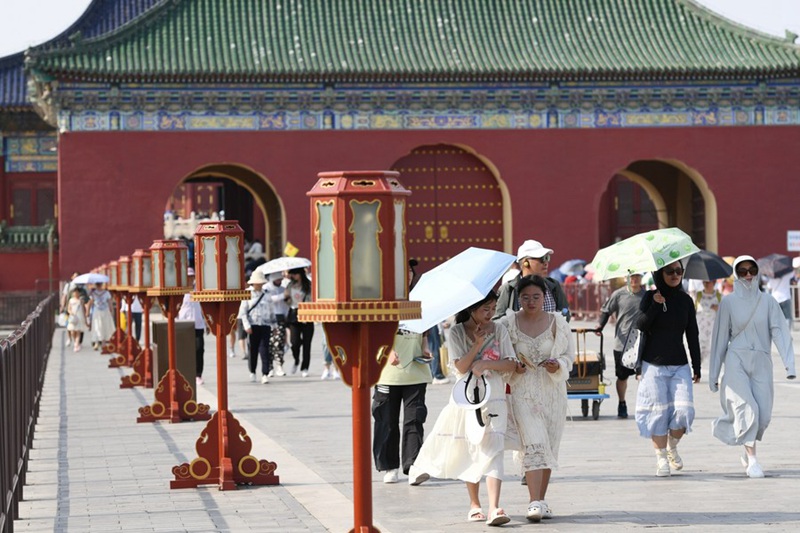 Watalii wakijikinga na jua kali kwa miavuli kwenye Hekalu la Tambiko la Mbingu hapa Beijing, China, Juni 23, 2023.(Xinhua/Ju Huanzong)