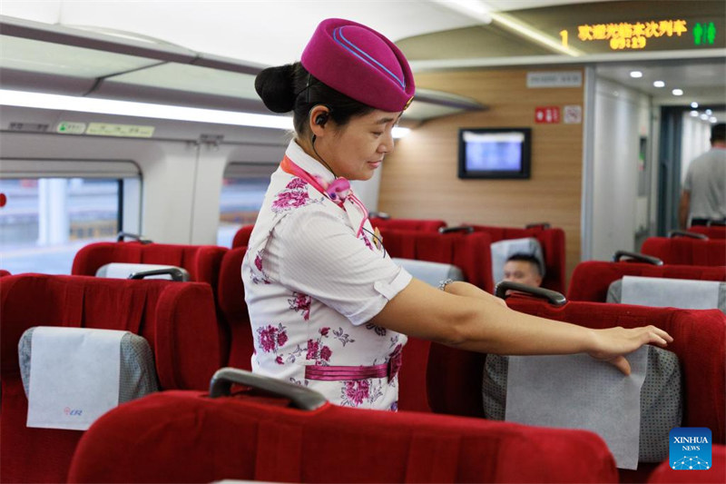 Mhudumu akifanya kazi kwenye treni ya majaribio katika Stesheni ya Guiyang Kaskazini huko Guiyang, Mkoa wa Guizhou, Kusini-Magharibi mwa China, Juni 26, 2023. Kuondoka  kwa treni ya majaribio nambari 55311 kutoka Stesheni ya Guyang Kaskazini, kumeonesha kwamba reli ya mwendo kasi ya Guiyang-Nanning imeanza rasmi majaribio yake ya uendeshaji siku ya Jumatatu.Reli hiyo  iliyojengwa  kutumika kwa treni zinazokimbia kwa kasi ya kilomita 350 kwa saa, inaunganisha Mji wa Guiyang wa Mkoa wa Guizhou na Mji wa Nanning  wa Mkoa unaojiendesha wa Guangxi, nchini China. (Xinhua/Liu Xu)