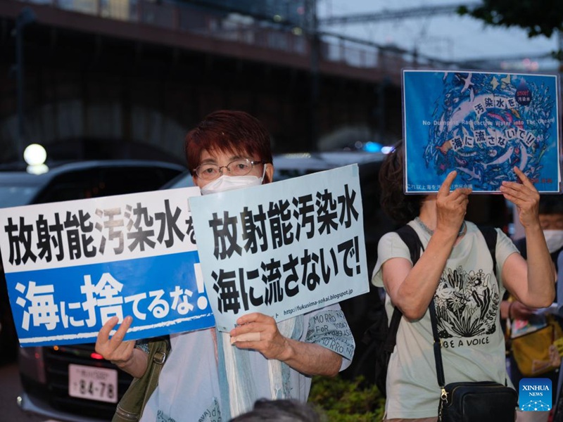 Waandamanaji wakiwa wamebeba mabango yenye maneno ya kupinga mpango wa Japan wa kutupa maji taka ya nyuklia baharini mbele ya makao makuu ya Kampuni ya Umeme ya Tokyo (TEPCO), ambayo ni mwendeshaji wa Kituo cha Nishati ya Nyuklia cha Fukushima Daiichi kilichoharibika, huko Tokyo, Japan, Julai 5, 2023. (Xinhua/Zhang Xiaoyu)