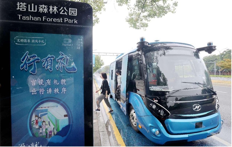 Abiria wakishuka kwenye basi linalojiendesha katika wilaya ya Deqing, mjini Huzhou, Zhejiang mashariki mwa China. (People