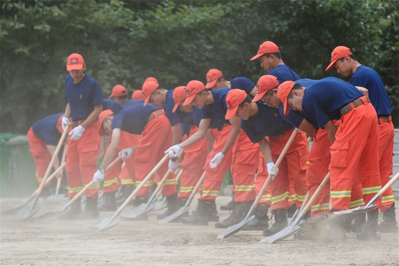 Wazima moto wakiwa wanasafisha barabara iliyochafuliwa na mafuriko katika mji wa Shangzhi, kaskazini-mashariki mwa Mkoa wa Heilongjiang China, Agosti 11, 2023. (Xinhua/Zhang Tao)