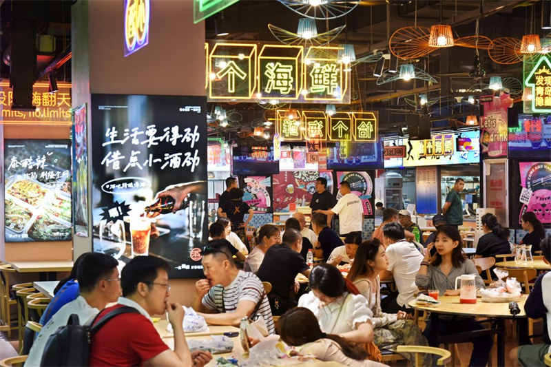 Watu wakila chakula kwenye Soko la Fushansuo katika Wilaya ya Shinan iliyoko Mji wa Qingdao, Mkoa wa Shandong, Mashariki mwa China, Agosti 7, 2023. (Xinhua/Li Ziheng)