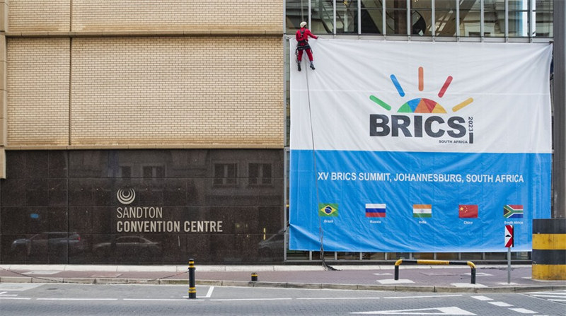 Mfanyakazi akipanga bango la mkutano wa 15 wa wakuu wa BRICS nje ya Kituo cha Mikutano cha Sandton huko Johannesburg, Afrika Kusini, Agosti 17, 2023. (Xinhua/Zhang Yudong)