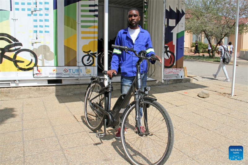 Mtu huyu akipiga picha pamoja na baiskeli inayotumia nishati ya umeme mjini Windhoek, Namibia, Agosti 31, 2023. (Picha na Musa C Kaseke/Xinhua)