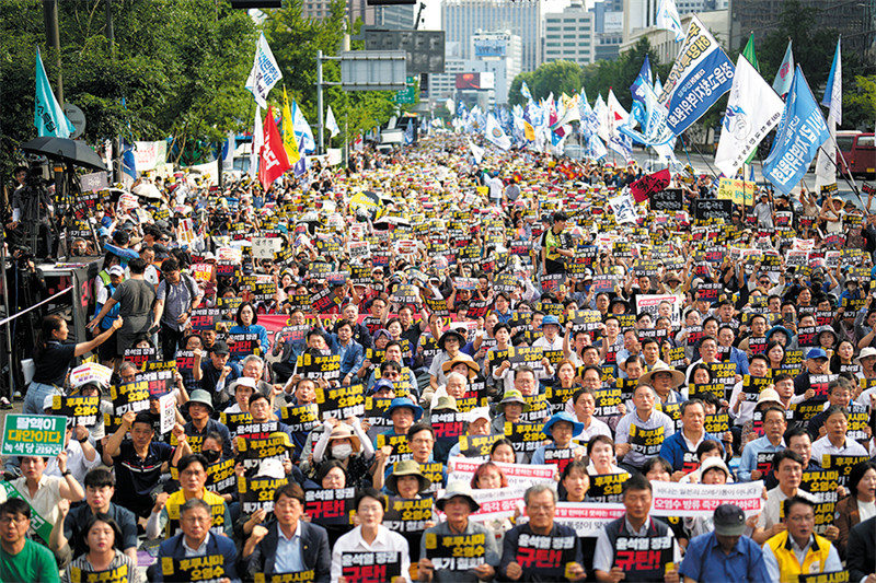 Waandamanaji wa Korea Kusini wakiingia mitaani mjini Seoul siku ya Jumamosi baada ya hatua ya Japan ya kutiririsha baharini maji machafu yenye mionzi ya nyuklia kutoka kinu cha nyuklia cha Fukushima Daiichi kilichoharibika. (LEE JIN-MAN/AP)