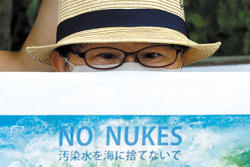 Mwandamanaji huko Tokyo, Japan akiwa ameshikilia bango lenye maandishi yanayosomeka kwa Lugha ya Kijapani "Usitiririshe maji machafu ya sumu baharini," wakati wa maandamano ya tarehe 25 Agosti kupinga Japan kutiririsha maji yenye sumu ya nyuklia. (KIM KYUNG-HOON/REUTERS)
