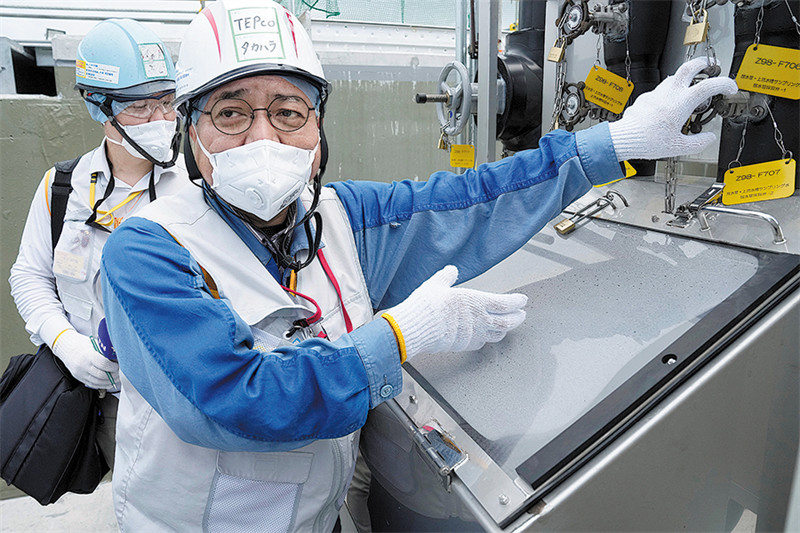 Afisa wa Kampuni ya Umeme ya Tokyo, kampuni ambayo ni mwendeshaji wa kinu cha Fukushima Daiichi, akizungumza kwenye kituo cha kuchukua sampuli za maji machafu ya sumu, huko Futaba, Japan, siku ya Jumapili. (REUTERS)