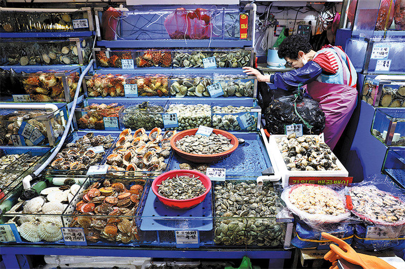 Mchuuzi wa samaki akisubiri wateja kwenye soko la samaki la Noryangjin, Julai 5 huko Seoul. (CHUNG SUNG-JUN/GETTY IMAGES)