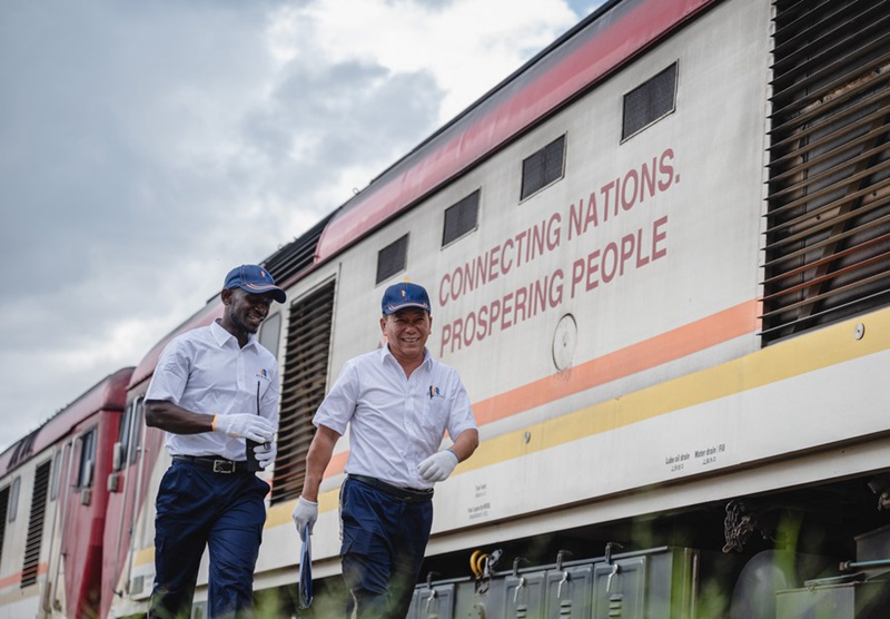 Mkufunzi kutoka China, Jiang Liping (Kulia) na mwanagenzi Horace Owiti wakitembea kulipita behewa la treni kwenye Reli ya SGR ya Mombasa-Nairobi mjini Nairobi, Kenya, Mei 23, 2023. Reli ya SGR ya Mombasa-Nairobi nchini Kenya imekuwa mradi kinara wa ushirikiano kati ya China na Afrika, "kadi ya biashara" ya kampuni za China na mradi kielelezo wa ujenzi wa pamoja wa Pendekezo la Ukanda Mmoja, Njia Moja. (Xinhua/Wang Guansen)