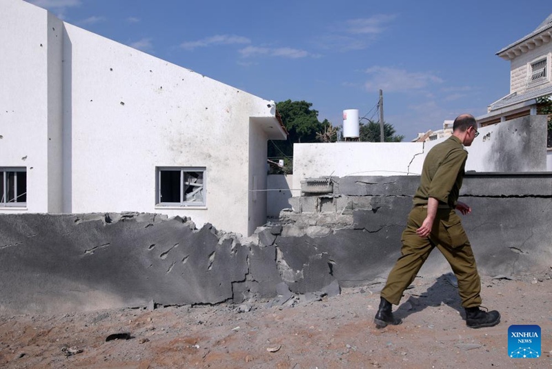 Picha iliyopigwa Oktoba 11, 2023 ikionyesha mtu akitembea kuupita ukuta uliobomolewa katika mashambulizi ya roketi kutoka Gaza, huko Ashkelon, Israel. (Ilan Assayag/JINI kupitia Xinhua)