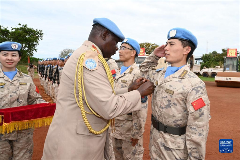 Kweku Dankwa Hagan, Kamanda wa Kisekta wa Kamandi ya Magharibi ya Kikosi cha Kulinda Amani cha UN nchini Sudan Kusini  akiwavalisha “Nishani ya Heshima ya Amani” ya Umoja wa Mataifa askari wa kulinda amani wa China kwenye hafla hiyo. (Picha na Li Feiyu/Xinhua)