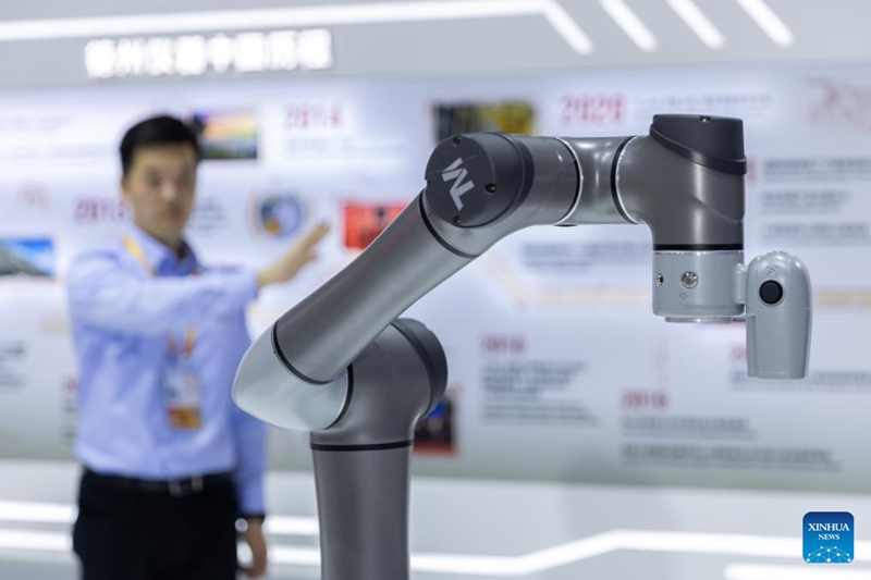 Mfanyakazi akidhibiti mkono wa roboti kwa ishara kwenye banda la Kampuni ya Texas Instruments katika Maonyesho ya 6 ya Kimataifa ya Uagizaji Bidhaa ya China (CIIE) mjini Shanghai, Mashariki mwa China, Novemba 9, 2023. (Xinhua/Wang Xiang). 