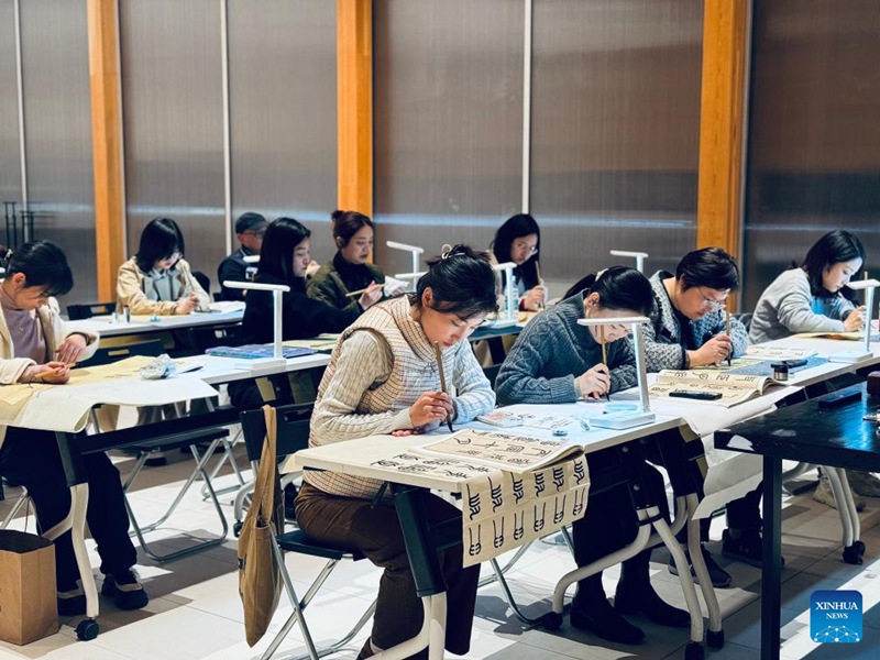 Watu wakihudhuria darasa la kaligrafia katika Kituo cha Ushirikiano kilichoko eneo la Jiangbei katika Mji wa Chongqing, Kusini Magharibi mwa China Novemba 24, 2023. (Picha na Wang Chao/Xinhua)