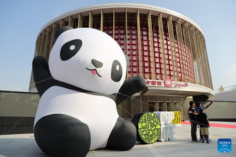 Watu wakipiga picha mbele ya banda la China kwenye Eneo la Kijani la Mkutano wa 28 wa Nchi Watia Saini wa Mkataba wa Umoja wa Mataifa wa Mabadiliko ya Tabianchi (COP28), mjini Dubai, Falme za Kiarabu, Desemba 3, 2023. (Xinhua/Wang Dongzhen)