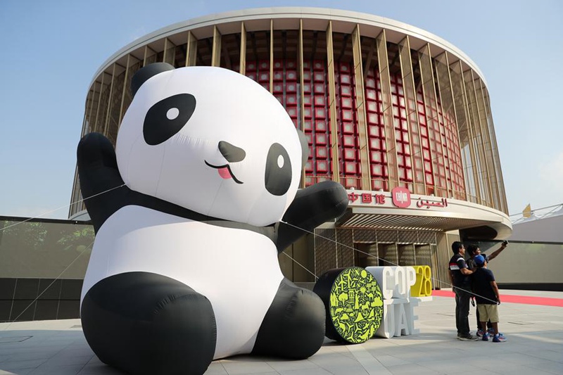 Watembeleaji wakipiga picha mbele ya Banda la China kwenye Eneo la Kijani la Mkutano wa 28 wa Nchi Watia saini wa Mkataba wa Umoja wa Mataifa wa Mabadiliko ya Tabianchi (COP28), mjini Dubai, Umoja wa Falme za Kiarabu, Desemba 3, 2023 (Xinhua/Wang Dongzhen)