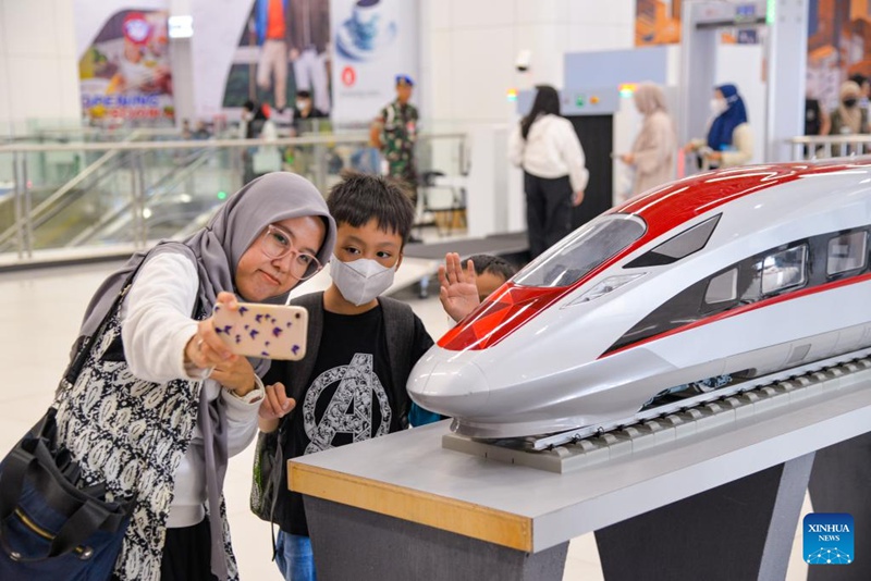 Abiria wakijipiga picha ya selfie pamoja na mfano wa treni ya mwendokasi inayotumia nishati ya umeme (EMU) ya reli ya mwendokasi ya Jakarta-Bandung katika Stesheni ya Halim mjini Jakarta, Indonesia, Desemba 17, 2023. (Xinhua/Xu Qin)