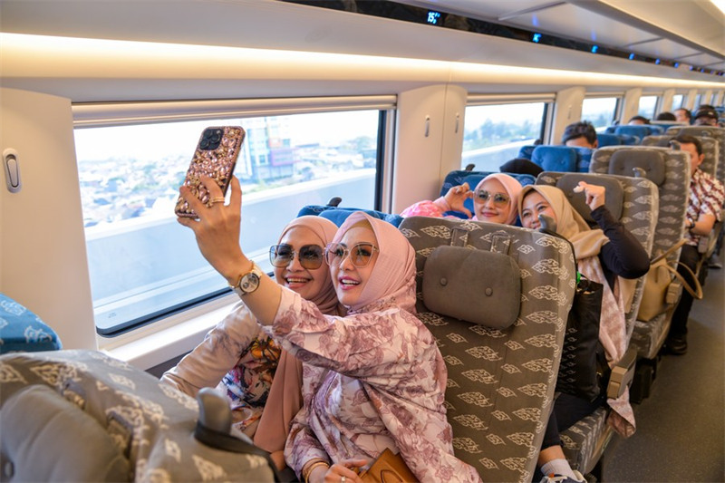 Abiria wakijipiga picha ndani ya behewa la treni ya mwendo kasi ya EMU inayotoa huduma kwenye Reli ya Mwendokasi ya Jakarta-Bandung nchini Indonesia, Oktoba 17, 2023. (Xinhua/Xu Qin)