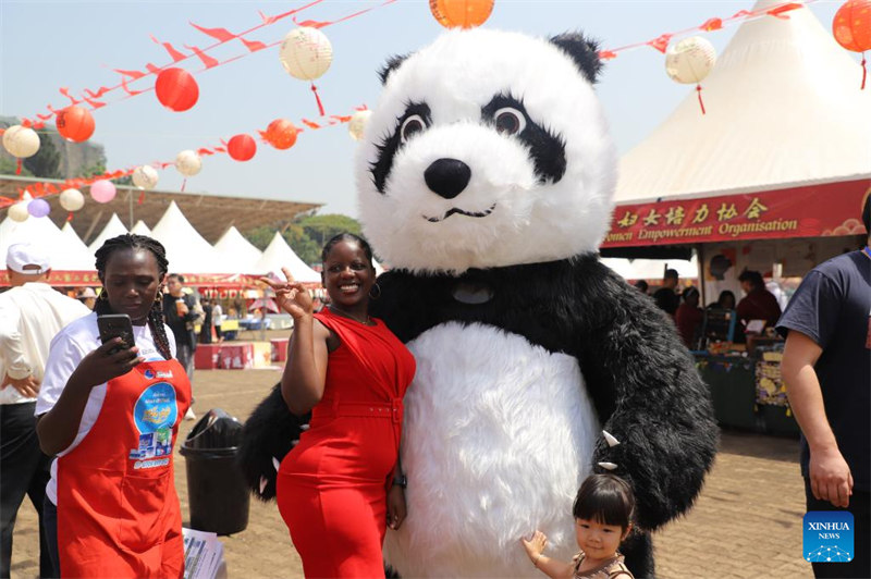 Mtu akipiga picha na maskoti wa panda kwenye Gulio la Mwaka Mpya wa Jadi wa China mjini Kampala, Uganda, Januari 28, 2024. (Picha na Hajarah Nalwadda/Xinhua)