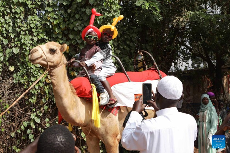 Watoto wakipiga picha juu ya ngamia wakati wa sherehe za sikukuu ya Eid el Fitr katika mtaa mjini Kampala, Uganda, Aprili 10, 2024. (Picha na Hajarah Nalwadda/Xinhua)