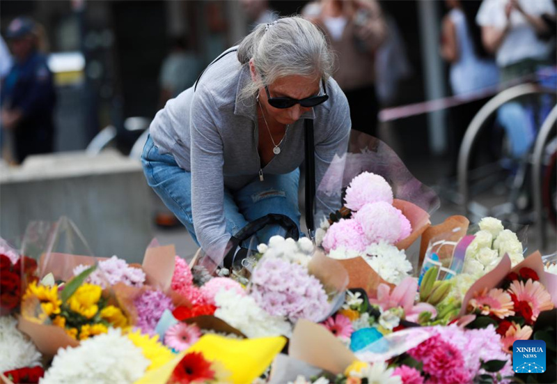 Mwanamke akiweka maua nje ya Jengo la Maduka la Westfield kwenye Makutano ya Bondi mjini Sydney, Australia, Aprili 14, 2024. (Xinhua/Ma Ping)