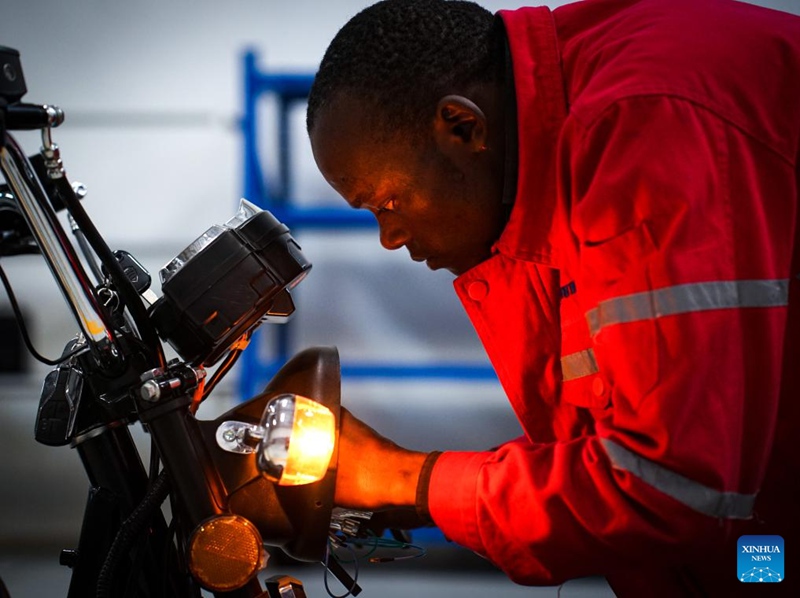 Mfanyakazi akiunganisha vifaa na sehemu za boda-boda inayotumia umeme kwenye bohari la Hanlin Africa huko Nairobi, Kenya Mei 2, 2024. (Xinhua/Li Yahui)