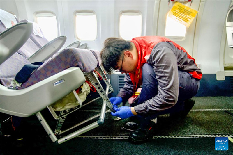 Mfanyakazi wa kampuni ya matengenezo ya Ndege ya Grand China (GCAM) akifanya kazi ndani ya chumba cha abiria cha ndege iliyoingia China kwenye sehemu ya maegesho ya ndege ya kituo cha matengemezo ya ndege huko Haikou, Mkoa wa Hainan, Kusini mwa China, Mei 13, 2024. (Xinhua/Zhang Liyun)