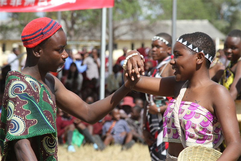 Watu waliovalia mavazi ya Kiafrika wakicheza ngoma wakati wa shughuli ya mawasiliao ya utamaduni ya China na Zimbabwe huko Goromonzi, ambayo ni jamii ya kijijini iliyoko Jimbo la Mashonaland Mashariki, Zimbabwe, Mei 23, 2024. (Xinhua/Tafara Mugwa)