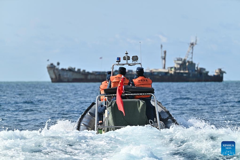 Watekelezaji wa sheria wa jeshi la askari polisi wa China kwenye bahari  wakikagua karibu na meli ya usafiri ya jeshi la majini la Ufilipino iliyokwamishwa baharini kinyume cha sheria tarehe 16 Mei, 2024. 