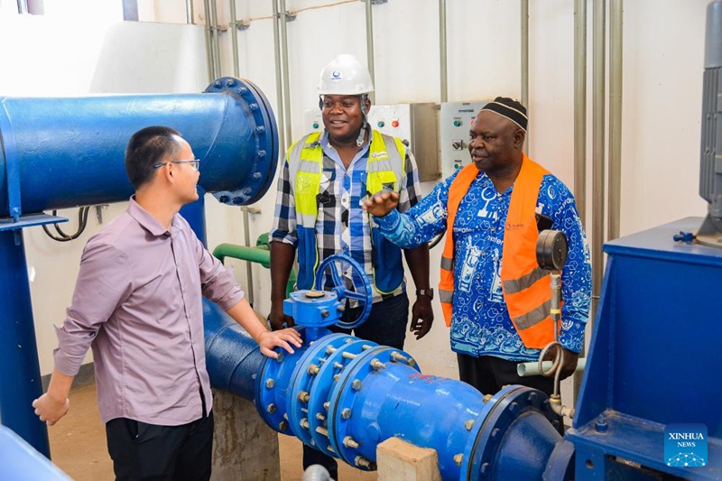 Mafundi wa Cameroon na China wakizungumza kwenye chumba cha mashine kwenye kiwanda cha kusafisha maji ya kunywa huko Bafoussam, Cameroon, Februari 20, 2024. (Picha na Kepseu/Xinhua)