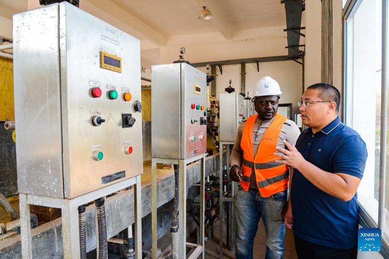 Mafundi wa Cameroon na China wakizungumza kwenye chumba cha mashine kwenye kiwanda cha kusafisha maji ya kunywa huko Bafoussam, Cameroon, Februari 20, 2024. (Picha na Kepseu/Xinhua)