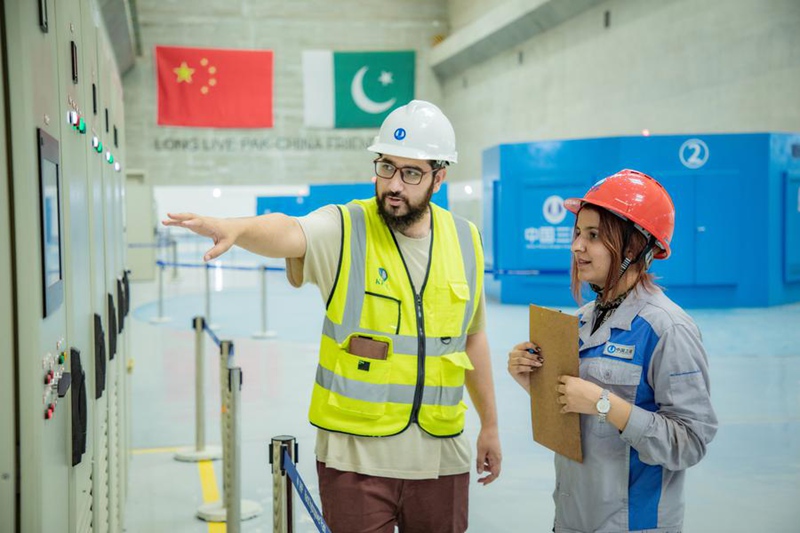 Moaaz Awan (kushoto) akifanya kazi kwenye Kituo cha Kuzalisha Umeme kwa Maji cha Karot katika Jimbo la Punjab, Mashariki mwa Pakistan, Mei 2023. (Xinhua)
