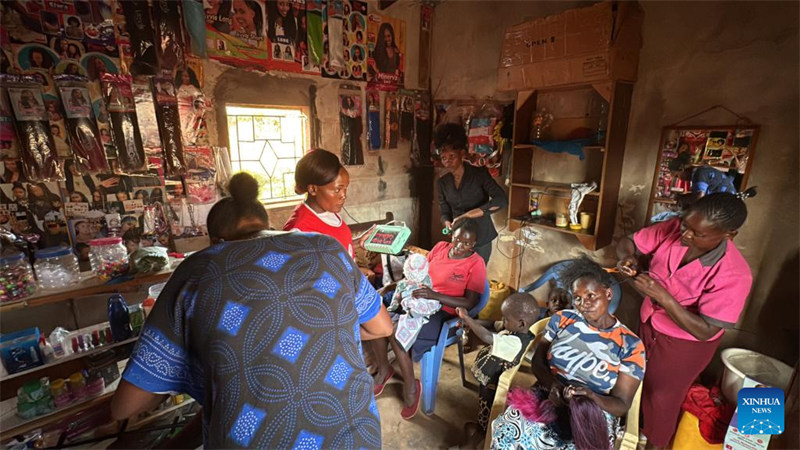 Wanawake wenyeji nchini Kenya wakishiriki kwenye somo la usukaji na ufungaji wa nywele linalotolewa kwa nji ya vishikwambi vinavyotumia nishati ya jua katika saluni ya muda huko Makueni, Kenya, Juni 6, 2024. (Picha na Lin Jing/Xinhua)